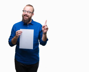 Genç hipster adam gözlük ve holding boş izole arka plan üzerinde bir fikir ile sürpriz kağıt veya gülen yüz, bir numara ile işaret parmağı soru