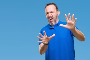 Şokta bağırarak orta yaş ağarmış üst düzey adam izole arka plan korkuyor ve korku ifade dur hareketi el ile ile çok korkmuş. Panik kavramı.
