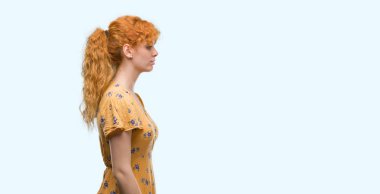 Tarafına, arayan genç Kızıl saçlı kadın dinlenmek doğal yüz emin gülümseme ile pozuyla profili.