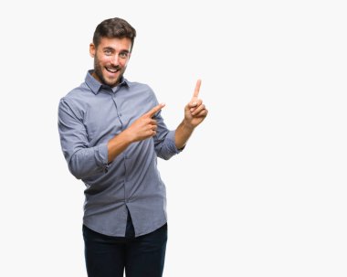 Yakışıklı delikanlı gülümseyen ve iki elleri ve parmakları ile tarafına işaret kamera bakarak izole arka plan üzerinde.