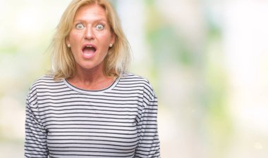 Orta yaş sarışın kadın izole arka plan korkuyor ve sürpriz ifade ile şok yüzünden korku ve yüz heyecanlı.