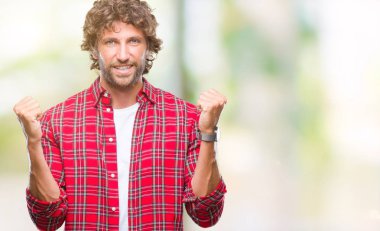 İzole arka plan kutlama üzerinden yakışıklı İspanyol modeli adam şaşırttı ve başarı için kaldırdı kollarını açarak hayret ve gözleri açık. Kazanan kavramı.