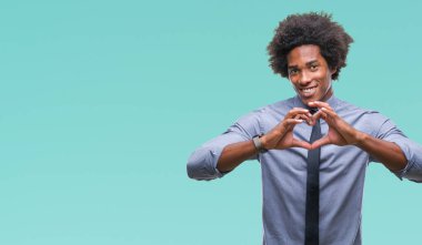 Kalp simgesi ve elleriyle şekil gösterilen aşık gülümseyen izole arka plan üzerinde Afro Amerikalı iş adamı. Romantik kavramı.