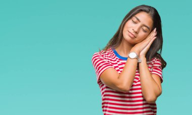 Genç güzel Arap kadın yüzünden uyku yorgun hayal ve ellerle birlikte poz ile kapalı gözler gülümseyen izole arka plan.