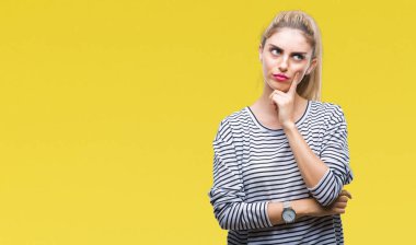 Üzerinde çizgili süveter giyen genç güzel sarışın kadın arka plan çene düşünme hakkında soru, dalgın ifade üzerine el ile izole. Düşünceli yüzüyle gülümsüyor. Şüphe kavramı.