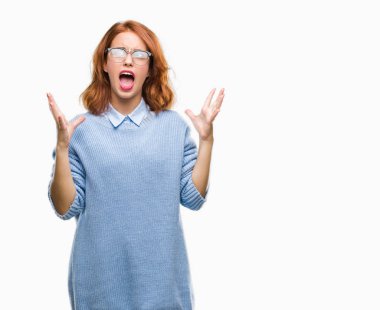 İzole arka plan kış kazak çılgın ve kızgın bağırarak ve agresif ifade ve silah kaldırdı bağırmaya giyen genç güzel kadın. Hayal kırıklığı kavramı.