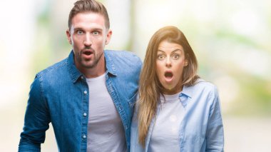 Genç çift aşık korkuyor ve şok sürpriz ifade ile izole arka plan üzerinde korku ve yüz heyecanlı.