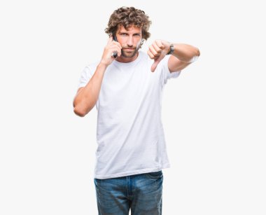 Kızgın yüzü, eksi işareti aşağı antipati başparmak ile gösterilen, ret kavramı ile izole arka plan üzerinde smartphone üzerinde konuşmak İspanyol yakışıklı modeli