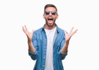 Yakışıklı delikanlı üzerinde güneş gözlüğü takıyor deli kutluyor arka plan izole ve silah ile başarı için yükseltilmiş ve açık gözleri heyecanlı çığlık hayrete düşürdü. Kazanan kavramı