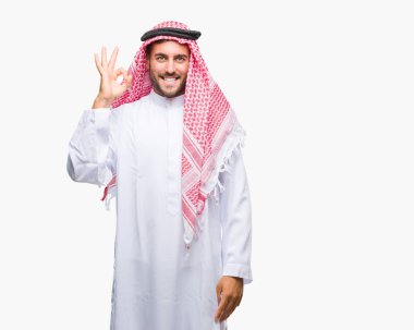 Keffiyeh izole arka plan el ve parmaklar ok işaretiyle yapıyor olumlu gülümseyen üzerinde giyen genç yakışıklı adam. Başarılı ifade.