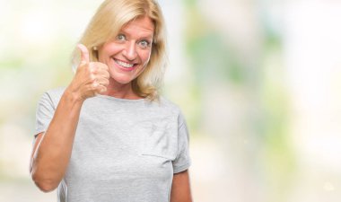 Orta yaş sarışın kadın hareketi el ile mutlu yaşasın yapıyor izole arka plan yüzünden. Kameraya bakarak başarı gösteren ile ifade onaylama.