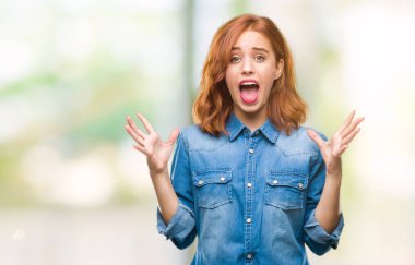 Genç güzel kadın deli kutluyor ve silah ile başarı için heyecanlı çığlık kaldırdı ve açık gözleri hayret izole arka plan yüzünden. Kazanan kavramı