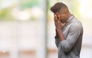 Afrikalı-Amerikalı genç yüz eller ile ağlayarak süre kapsayan üzgün ifade ile izole arka plan üzerinde. Depresyon kavramı.