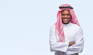 Geleneksel keffiyeh üzerinde giyen genç Arapça Afrika adam mutlu yüz ile gülümseyerek kameraya seyir silah geçti arka plan izole. Olumlu bir kişi.