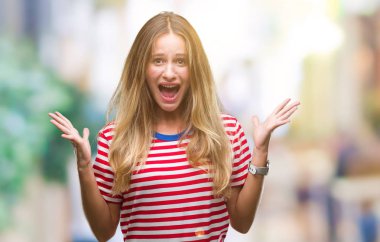 Genç güzel sarışın kadın deli kutluyor ve silah ile başarı için heyecanlı çığlık kaldırdı ve açık gözleri hayret izole arka plan yüzünden. Kazanan kavramı