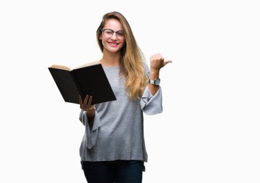 Genç güzel sarışın kadın işaret ve başparmak kadar mutlu yüz gülümseyen tarafı ile gösteren izole arka plan üzerine bir kitap okuma