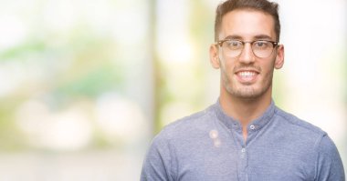 Yüzünde mutlu ve güzel bir gülümseme ile gözlüklü zarif yakışıklı genç. Şanslı kişi.