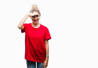 Kırmızı t-shirt ve gözlük üzerinde giyen genç güzel sarışın kadın arka plan çok mutlu ve gülümseyen uzakta el ile üzerine kafa seyir izole. Arama kavramı.