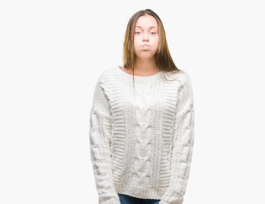 Komik surat ile yanakları şişirme izole arka plan üzerinde kış kazak giyen genç güzel beyaz kadın. Ağız ile hava, deli ifade şişirilmiş.