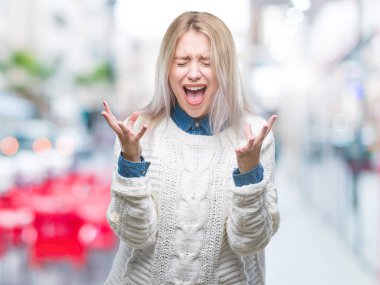 Üzerinde kış kazak giyen genç sarışın kadın arka plan deli izole ve deli bağırarak ve agresif ifade ve silah kaldırdı bağırıyor. Hayal kırıklığı kavramı.