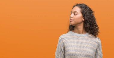 Görünümlü yan ve dik dik bakma uzağa düşünce gülümseyen çizgili süveter giyen güzel genç İspanyol kadın.