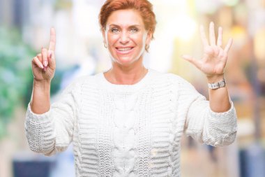 Gösterilen arka plan üzerinde kış kazak giyen Atrractive üst düzey beyaz Kızıl saçlı kadın izole ve parmakları ile işaret kendinden emin ve mutlu gülümseyerek süre 6 numara.