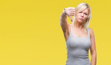 Genç güzel sarışın kadın yüzünden mutsuz ve kızgın ret gösterilen ve başparmak aşağı hareketi ile negatif seyir izole arka plan. Kötü ifade.