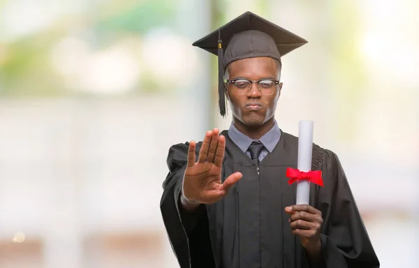 ヤング卒業防衛ジェスチャー 深刻な自信を持って式に一時停止の標識を行うオープンの手で隔離された背景の上の学位を保持するアフリカ系アメリカ人 — ストック写真