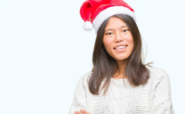 若いアジア女性をクリスマスの帽子をかぶっては 幸せそうな顔を浮かべて組んだ腕のカメラを見て背景を隔離しました 肯定的な人 — ストック写真
