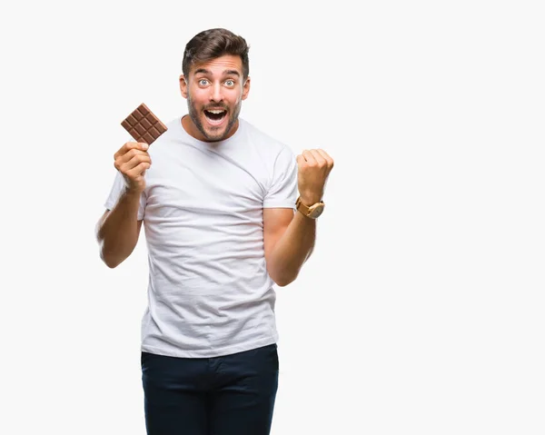 Όμορφος Νεαρός Τρώει Σοκολάτα Πέρα Από Απομονωμένο Υπόβαθρο Ουρλιάζοντας Περήφανος — Φωτογραφία Αρχείου