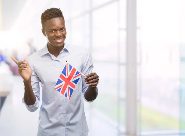 非常に幸せな側の手と指で指すイギリス フラグを保持若いアフリカ系アメリカ人 — ストック写真