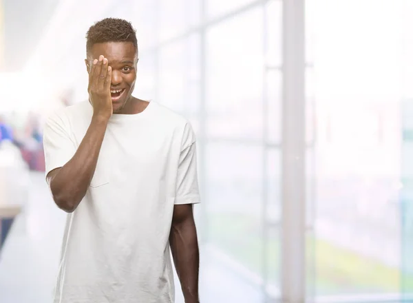 Joven Hombre Afroamericano Vistiendo Camiseta Blanca Cubriendo Ojo Con Mano —  Fotos de Stock