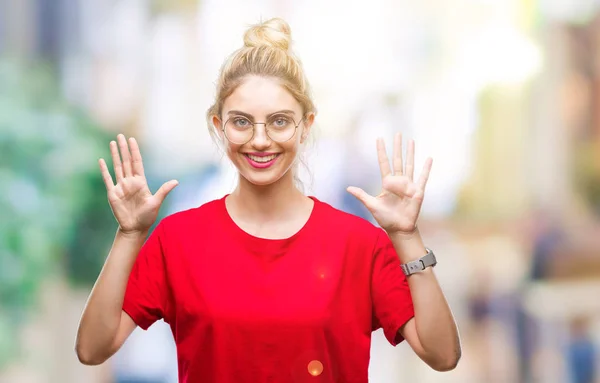年轻美丽的金发碧眼的女人穿着红色的 T恤和眼镜在孤立的背景显示和手指数字十 而微笑着自信和快乐 — 图库照片