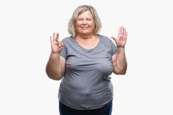 高级加尺寸的白种女人在孤立的背景显示和指向与手指数八 而微笑着自信和快乐 — 图库照片