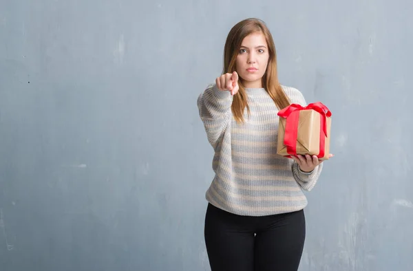 Junge Erwachsene Frau Über Grauer Grunge Wand Mit Einem Geschenk — Stockfoto