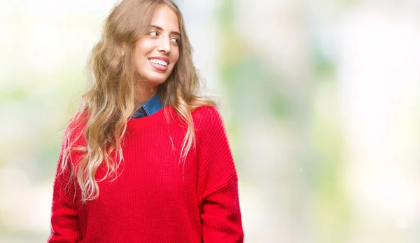 美丽的年轻金发女子穿着冬季毛衣在孤立的背景看一边与微笑的脸上 自然的表达 笑的自信 — 图库照片