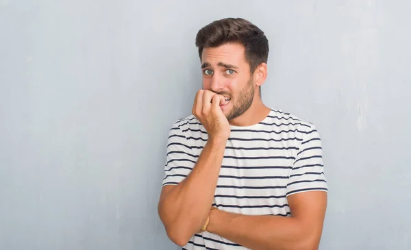 Hombre Joven Guapo Sobre Pared Gris Grunge Usando Una Camiseta — Foto de Stock