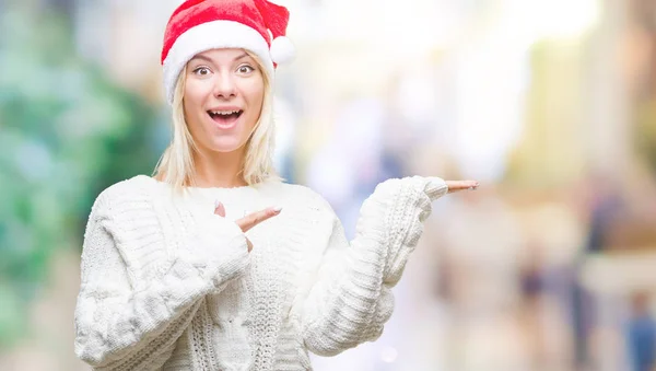 놀라게 손으로 손가락으로 가리키는 카메라에 크리스마스 모자를 금발의 — 스톡 사진