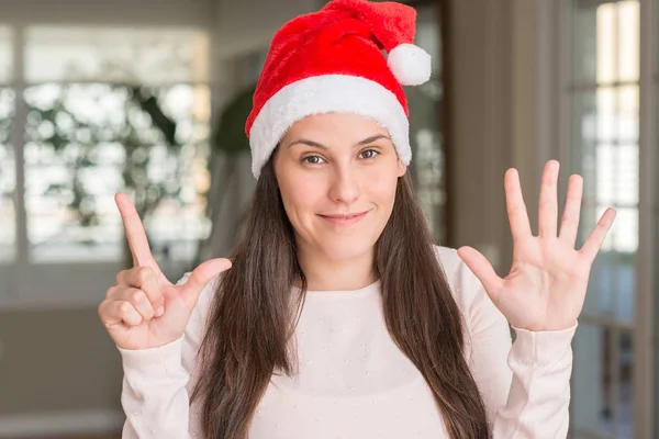 Vacker Ung Kvinna Som Bär Jultomten Hatt Hemma Visar Och — Stockfoto