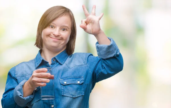 優秀なシンボルの指で サインをして孤立した背景の上ダウン症飲料水と若い成人女性 — ストック写真