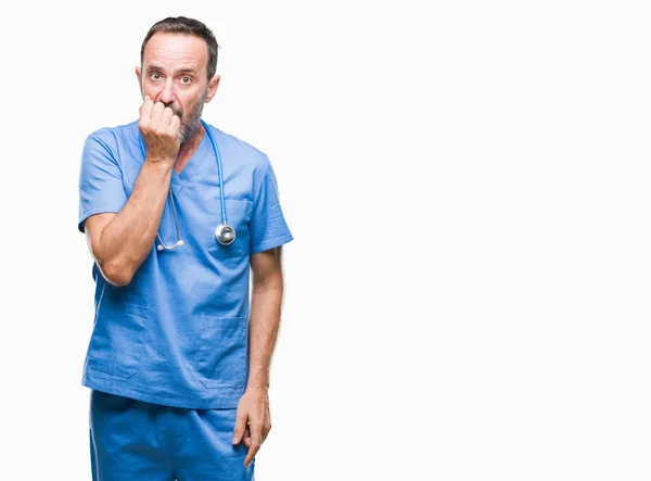 不安や両手の爪を噛んで口の中で緊張を探して孤立の背景に医療制服を着て中年白髪の先輩医師の男 不安の問題 — ストック写真