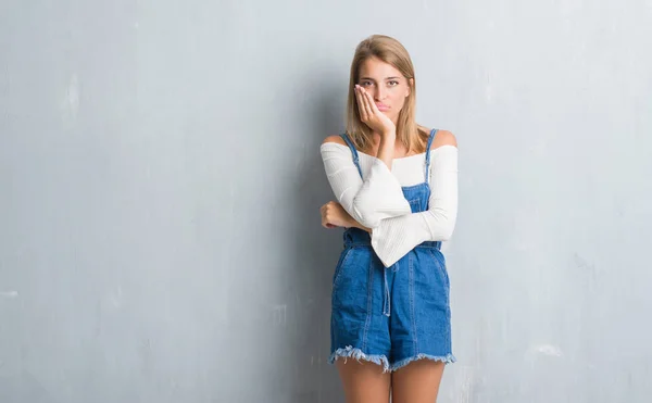 Mulher Bonita Sobre Grunge Parede Cinza Pensando Que Parece Cansado — Fotografia de Stock