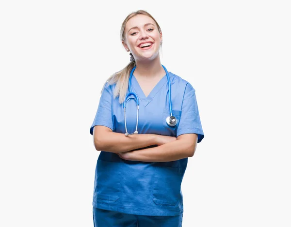 組んだ腕のカメラを見て笑みを浮かべて隔離された背景の幸せそうな顔で若い金髪外科医医師女性 肯定的な人 — ストック写真