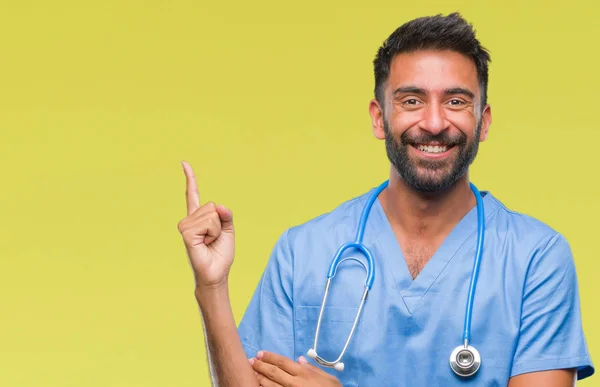 成人西班牙裔医生或外科医生的人在孤立的背景下 脸上的一个大微笑 指着手和手指 侧面看着相机 — 图库照片