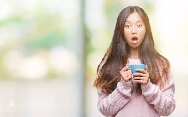 Junge Asiatische Frau Die Kaffee Über Isoliertem Hintergrund Trinkt Erschrocken — Stockfoto