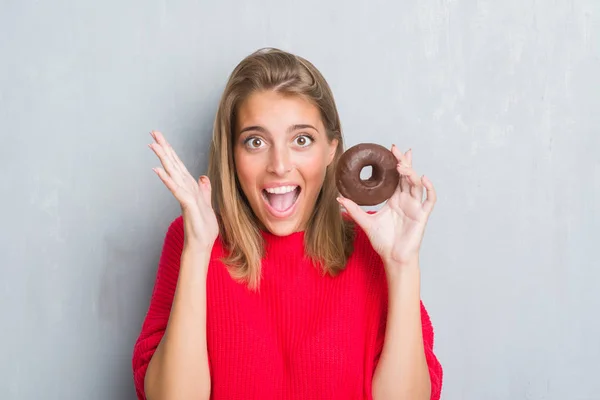 Hermosa Joven Sobre Pared Gris Grunge Comiendo Donut Chocolate Muy —  Fotos de Stock