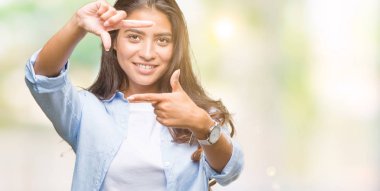 Genç güzel Arap kadın elle yapma çerçeve ve parmakları ile mutlu yüz gülümseyen izole arka plan yüzünden. Yaratıcılık ve Fotoğrafçılık kavramı.