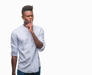 Afrikalı-Amerikalı genç dudaklarında parmak ile sessiz olmanı izole arka plan üzerinde. Sessizlik ve gizli kavramı.