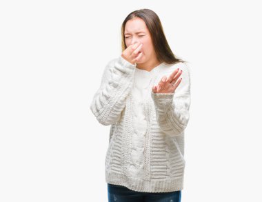 İzole arka plan kokulu üzerinde kış kazak pis ve iğrenç bir şey, dayanılmaz koku, holding nefes parmak ile burun üzerinde giyen genç güzel beyaz kadın. Kötü kokuyor kavramı.