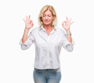Orta yaş sarışın iş kadını izole arka plan üzerinde dinlenmek ve gülümseyen gözlerle parmak ile meditasyon jest yapıyor kapalı. Yoga kavramı.